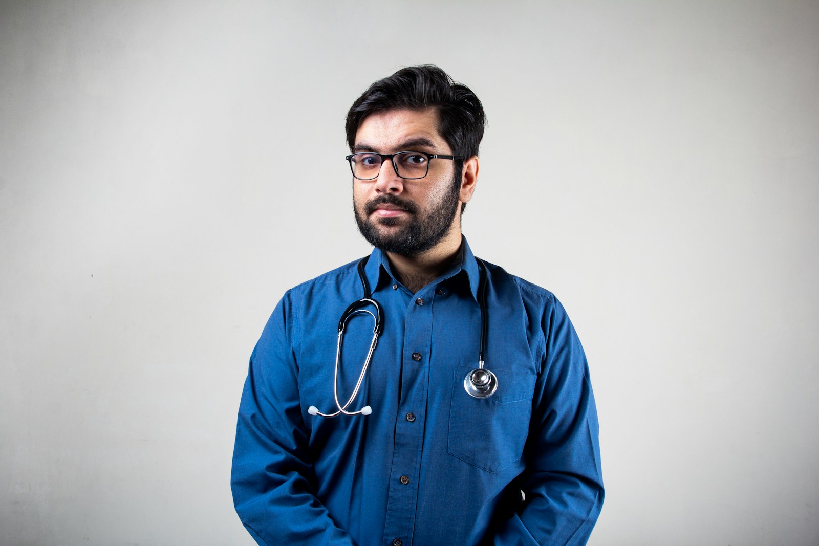 man in blue dress shirt wearing black framed eyeglasses